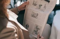 a lady reading a news paper